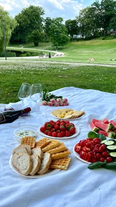 a table topped with plates of fruit and sandwiches