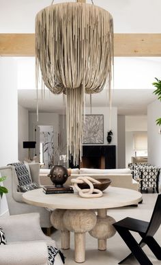 a living room filled with furniture and a large chandelier hanging from the ceiling