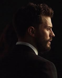 a man in a tuxedo looks off into the distance