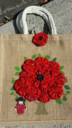 a bag with red flowers on it sitting on the ground