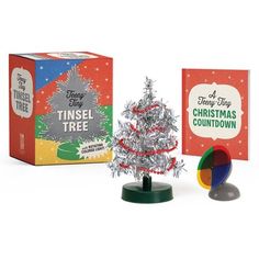 a tinsel christmas tree next to a boxed box