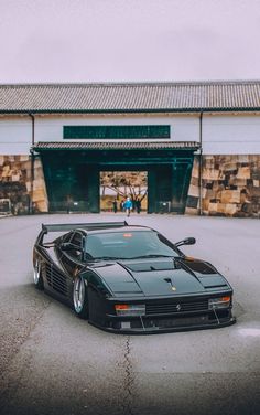 a black sports car parked in front of a building