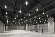 an empty room with lots of lights hanging from the ceiling and chairs on the floor