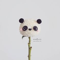 a stuffed panda bear sitting on top of a plant