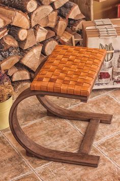 a wooden bench sitting on top of a tile floor next to stacks of wood and books