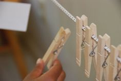 a person holding a wooden peg board with clothes pins attached to it