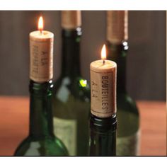 three wine bottles with candles in them sitting next to each other