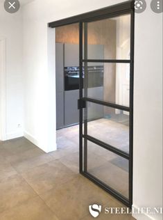 an empty room with glass doors and tile flooring in front of a stove top oven