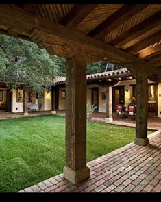 an outdoor patio with brick pavers and green grass