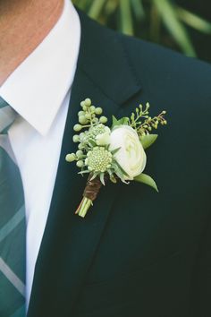 a man in a suit and tie with a boutonniere on his lapel