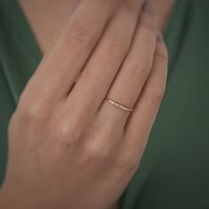 a woman's hand with a diamond ring on her left hand, wearing a green dress