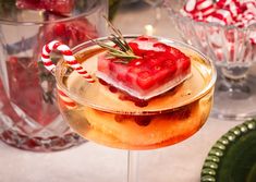 a drink in a wine glass with candy canes