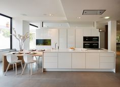 a modern kitchen with white cabinets and an island in front of a large glass window