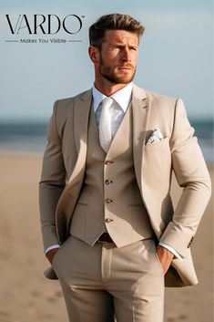 a man in a tan suit standing on the beach