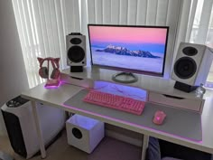 a desk with a computer and speakers on it