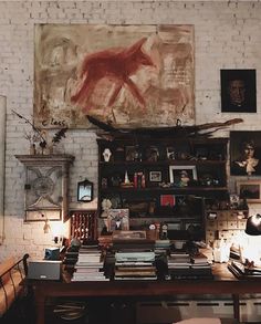 a room filled with lots of books and furniture next to a painting on the wall