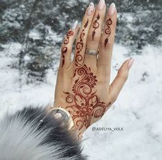 a woman's hand with henna tattoos on it