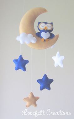 an owl is sitting on the moon mobile