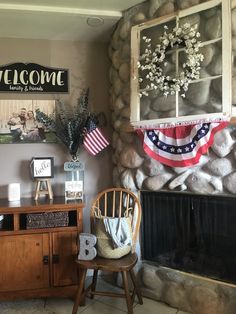 an american flag hanging on the wall next to a fireplace with a welcome sign above it