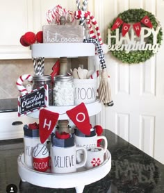 a stack of coffee mugs sitting on top of a counter next to a wreath