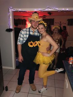 a man and woman dressed up as sunflowers pose for a photo in the kitchen