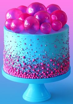 there is a cake with pink and blue icing on it that looks like bubbles