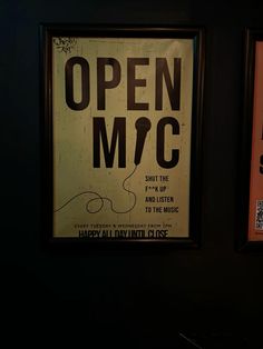 an open m & c sign hanging on the wall next to another sign that says it's open