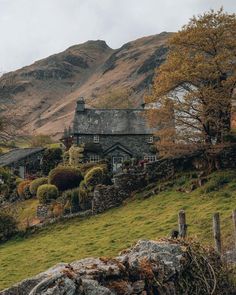 a house on a hill with mountains in the background