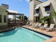 an empty swimming pool with lounge chairs next to it