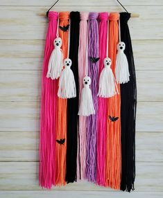 halloween decorations hanging on a wall with long tassels and skulls in the middle