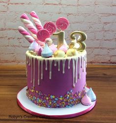 a birthday cake decorated with candy, candies and icing on a wooden table