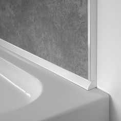 the corner of a bathroom with a white bathtub and gray wall paper on it