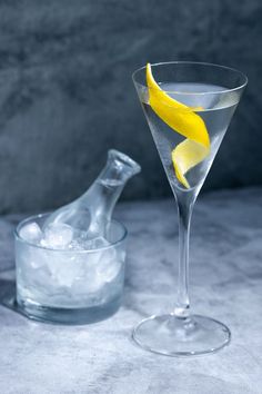 a glass filled with ice and a lemon peel