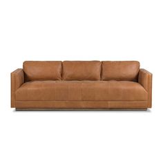 a brown leather couch with two pillows on it's back and one arm facing the camera