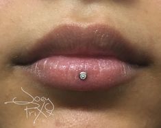 a woman's lips with a diamond on the tip of her lip and nose