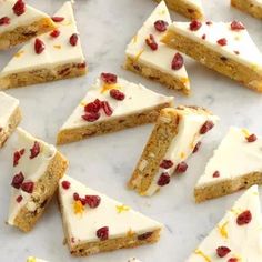 several pieces of cake with white frosting and cranberries