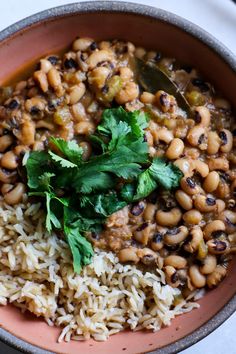 a bowl filled with rice, beans and cilantro on top of a table