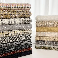 a stack of different colored fabrics sitting on top of a white table next to each other