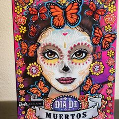 a painting of a woman with butterflies on her face and the words dia de muertos written in spanish