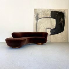 a couch sitting in front of a painting on the wall