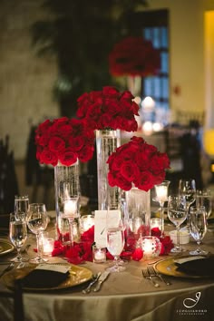 the centerpieces are adorned with red flowers and greenery