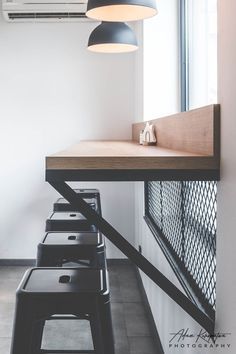 a row of black and white stools in front of a wall mounted air conditioner