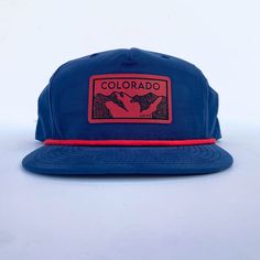 Everyone loves a good, comfy hat. How about one with a little bit of flair that helps you rep your favorite state?! Ooohhh yeah, we have our Colorado mountains patch now in red on a navy five panel rope hat! Grab your today for your next mountain adventure! Moisture wicking with UPF 50+ tech. One size. Adjustable. Red Curved Brim Trucker Hat For Outdoor Activities, Red Snapback Baseball Cap For Outdoor Activities, Adjustable Trucker Hat Made In Usa For Outdoor, Outdoor Snapback Hat With Flat Bill Made In Usa, Red Baseball Cap Snapback For Outdoor Activities, Red Snapback Hat For Outdoor Activities, Adjustable Baseball Cap Made In Usa For Outdoor, Adjustable Outdoor Trucker Hat Made In Usa, Red Curved Brim Hats For Outdoor Activities