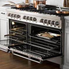 an oven with two burners and three pans on the top shelf in a kitchen