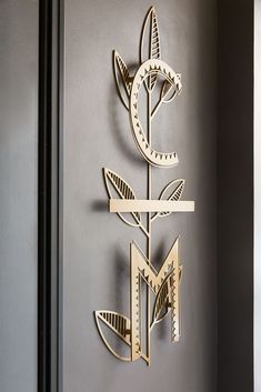 a metal wall decoration with flowers on it's side and an arrow in the middle