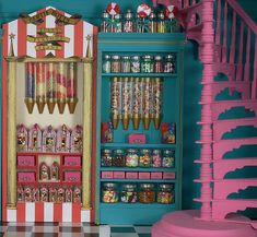 a room filled with lots of candy and toys on shelves next to a spiral stair case