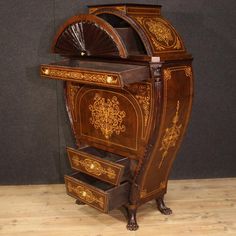 an old fashioned wooden cabinet with drawers and fan on the top, sitting on a hard wood floor