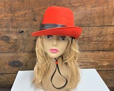 "Pretty vintage wool felt cloche hat, by Henry Pollack. It is an orange/red color. It has a brown vinyl sash around the middle with buckle that extends down under the chin. Really cute hat that will add pizzazz to any outfit. It has a 21\" circumference. 5\" tall In very good condition with no flaws. 100% wool felt, Made in USA. Please visit our shop to view our entire vintage selection at CobbledStreets: https://www.etsy.com/shop/CobbledStreets?ref=hdr_shop_menu Thank you for shopping at Cobble Pink Hat Outfit, Cute Hat, Retro Cats, Cloche Hat, Pink Hat, Vintage Orange, Outfits With Hats, Cute Hats, Red Wool