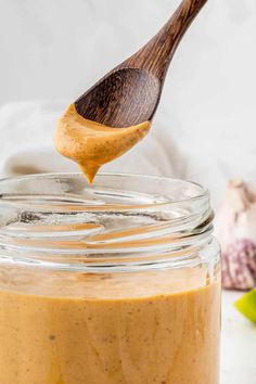 a wooden spoon in a jar filled with peanut butter