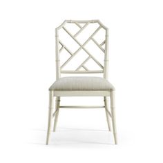 a white chair with a beige upholstered back and seat cushion on the side